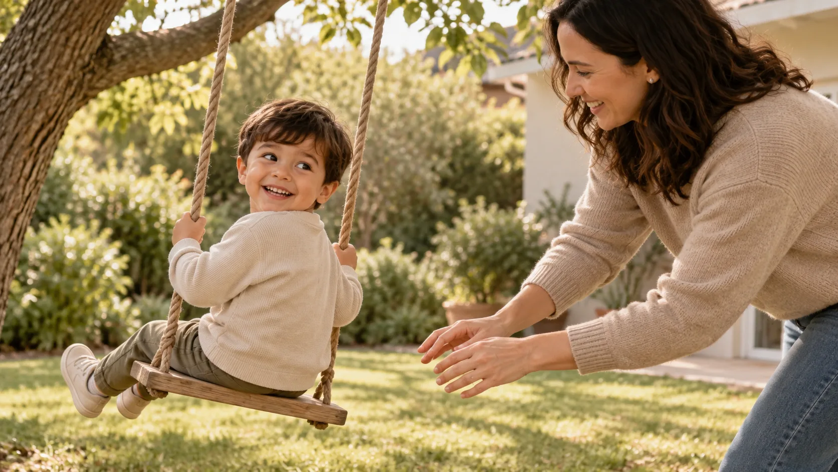 An adult gently pushes a child on a swing